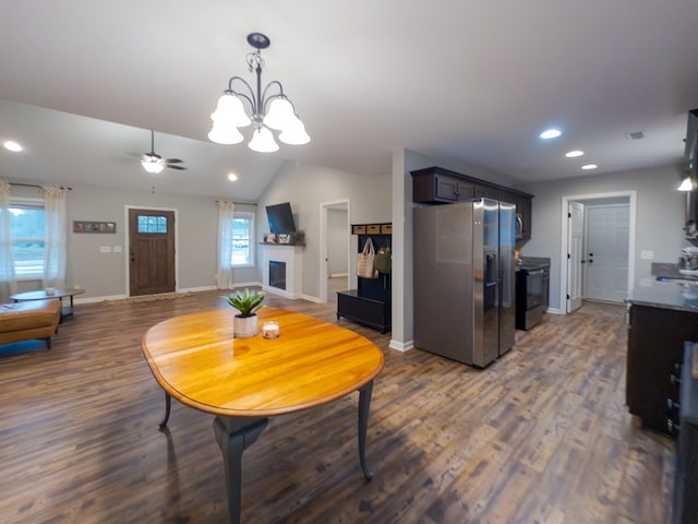 dining area featuring ceiling fan with notable chandelier, dark hardwood / wood-style floors, and lofted ceiling