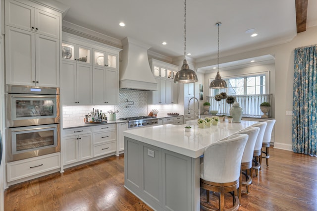 kitchen featuring white cabinetry, dark wood-type flooring, a kitchen island with sink, and custom exhaust hood