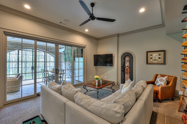 living room featuring carpet floors, ornamental molding, and ceiling fan