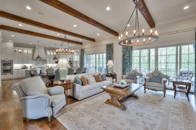 living room with an inviting chandelier, hardwood / wood-style floors, and beam ceiling