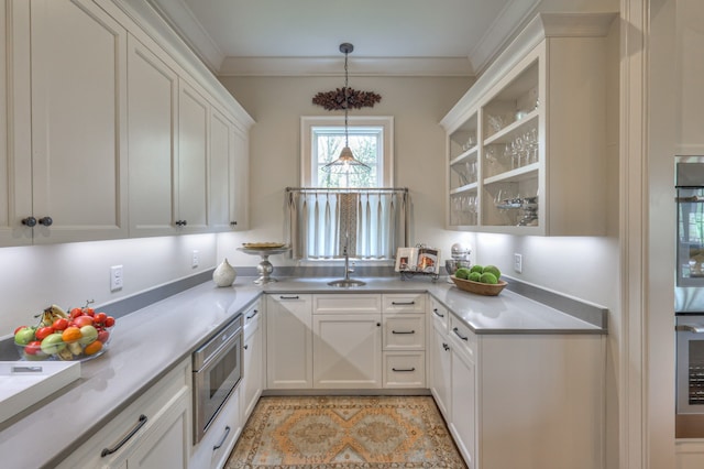 kitchen featuring ornamental molding, sink, decorative light fixtures, white cabinetry, and stainless steel appliances