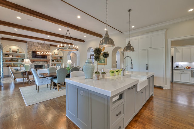 kitchen with pendant lighting, a large island, sink, and dark hardwood / wood-style flooring