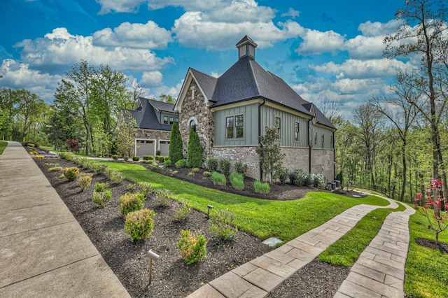 view of side of property with a yard and a garage