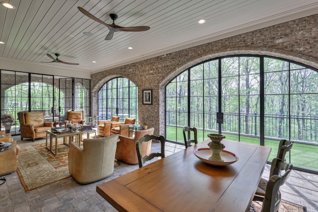 sunroom featuring wooden ceiling, a healthy amount of sunlight, and ceiling fan