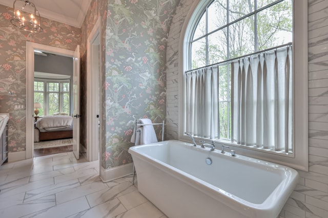 bathroom featuring a bathtub, plenty of natural light, and a chandelier