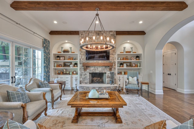 living room with a stone fireplace, beam ceiling, and hardwood / wood-style floors