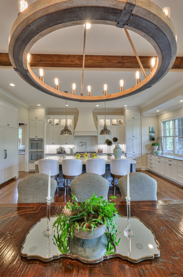 interior space featuring beamed ceiling, hardwood / wood-style flooring, and crown molding