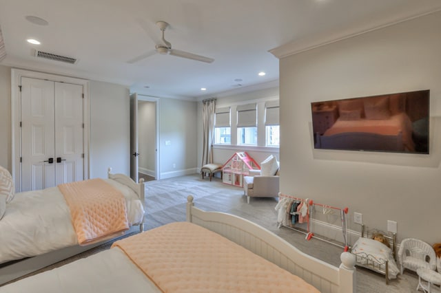 bedroom with light carpet, a closet, ceiling fan, and crown molding