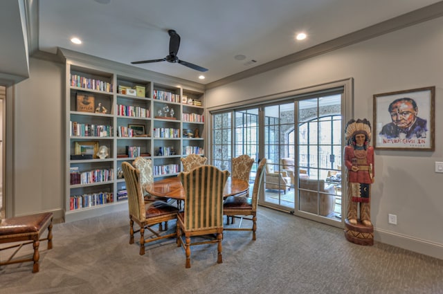 carpeted dining room featuring ceiling fan and ornamental molding