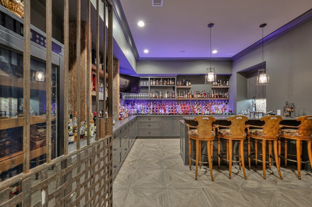 bar with light parquet floors, ornamental molding, and pendant lighting