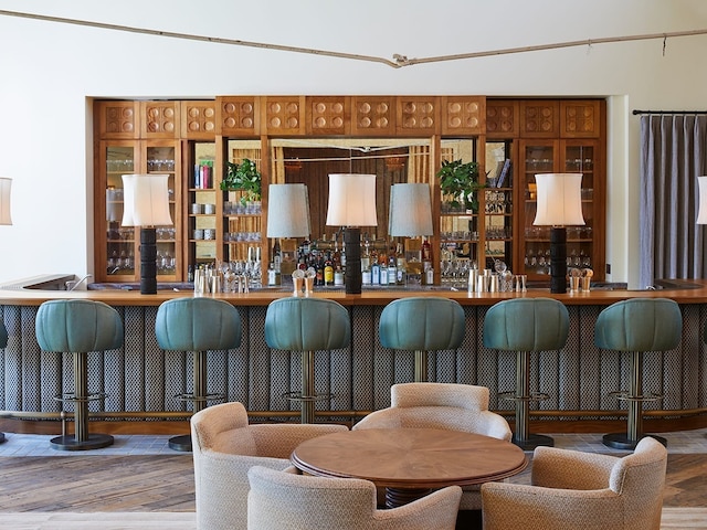 bar with wood-type flooring and lofted ceiling