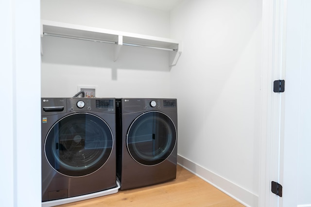 washroom featuring hardwood / wood-style flooring and washer and dryer