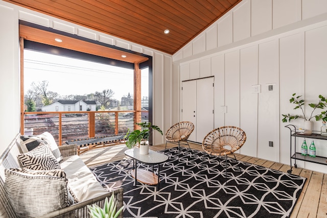 living area with wood-type flooring, wood ceiling, and lofted ceiling