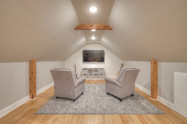 living area featuring lofted ceiling and hardwood / wood-style floors