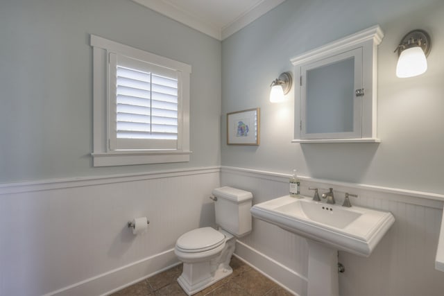 bathroom featuring crown molding, tile patterned floors, and toilet