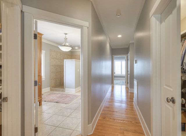 corridor featuring ornamental molding and light hardwood / wood-style floors