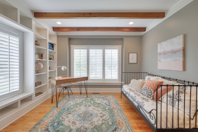 home office featuring light hardwood / wood-style flooring and beamed ceiling