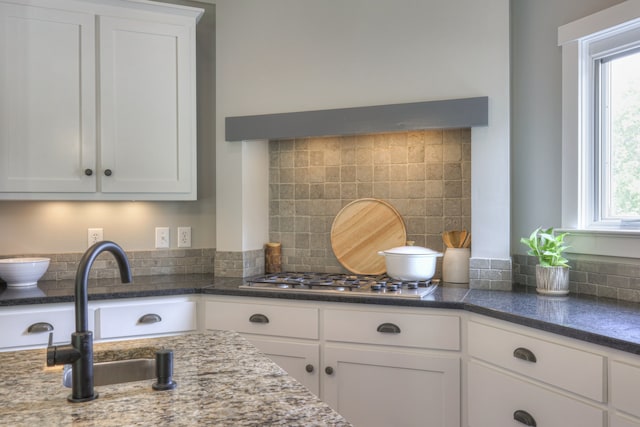 kitchen with a healthy amount of sunlight, white cabinetry, and tasteful backsplash