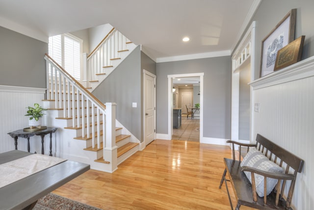 entryway with crown molding and hardwood / wood-style flooring