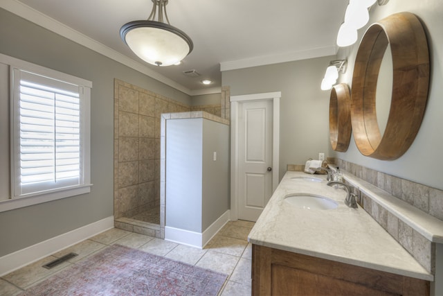 bathroom with a tile shower, tile patterned floors, vanity, and crown molding