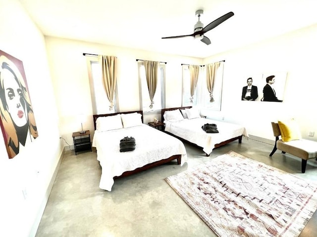 bedroom featuring baseboards, ceiling fan, and concrete flooring