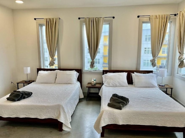 bedroom with concrete flooring and recessed lighting