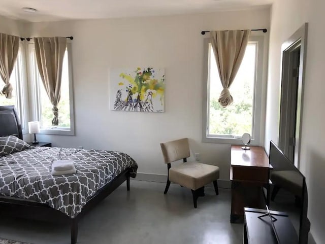 bedroom with baseboards and finished concrete floors