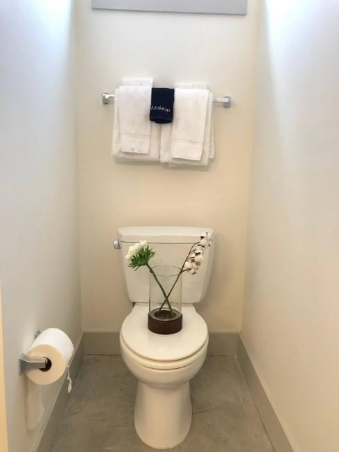 bathroom with baseboards and toilet