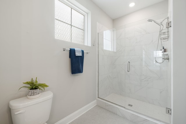 bathroom with a shower with door and toilet