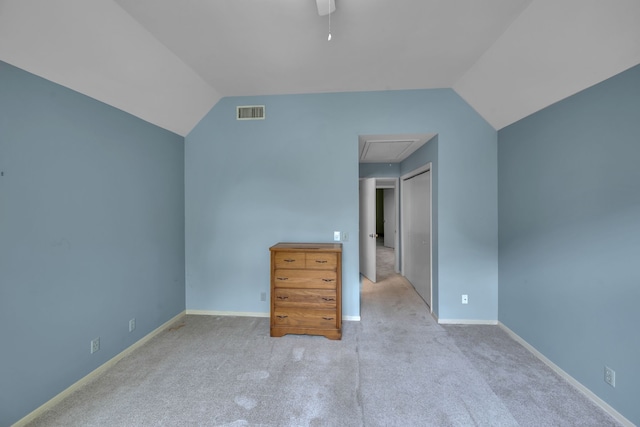 unfurnished bedroom featuring lofted ceiling, ceiling fan, light carpet, and a closet