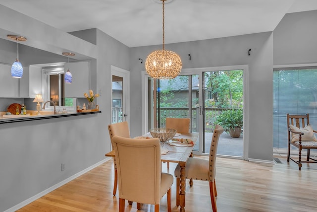 dining space featuring light hardwood / wood-style flooring and a chandelier