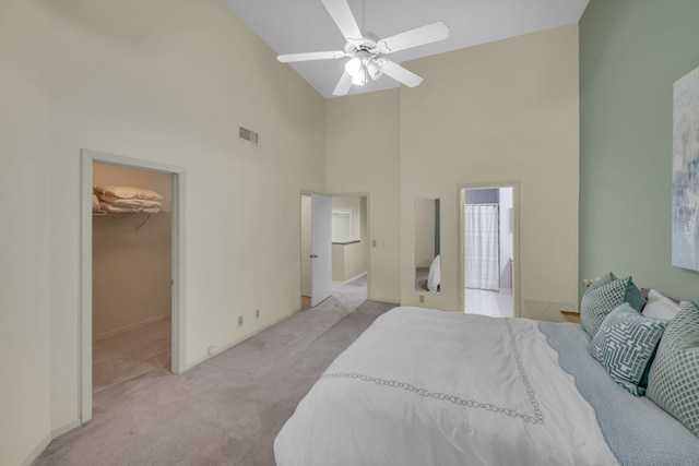 carpeted bedroom with ceiling fan, a closet, high vaulted ceiling, and a walk in closet