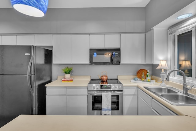 kitchen with black appliances, white cabinetry, and sink