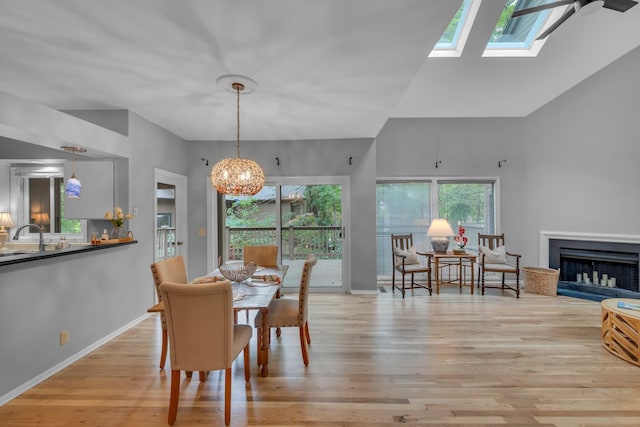 dining room with a skylight, light hardwood / wood-style flooring, and a healthy amount of sunlight