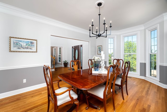 dining area featuring an inviting chandelier, light hardwood / wood-style flooring, and ornamental molding