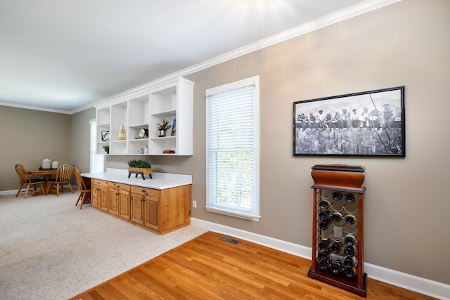 kitchen with light hardwood / wood-style flooring and crown molding