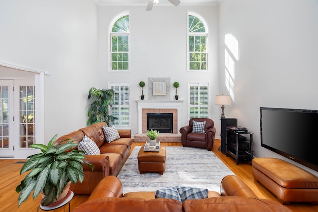 living room featuring ornamental molding, hardwood / wood-style floors, and a brick fireplace