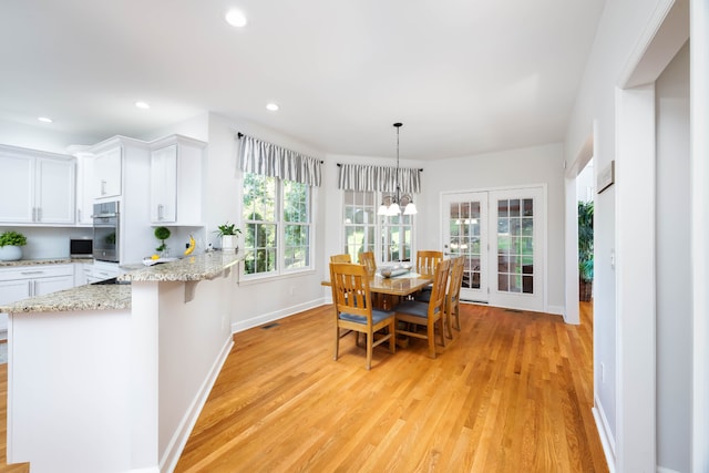 dining room featuring light hardwood / wood-style flooring, a chandelier, and plenty of natural light