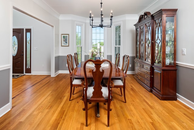 dining area featuring light hardwood / wood-style flooring, a notable chandelier, and ornamental molding