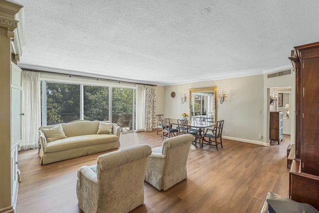 living room featuring hardwood / wood-style flooring, crown molding, and a textured ceiling