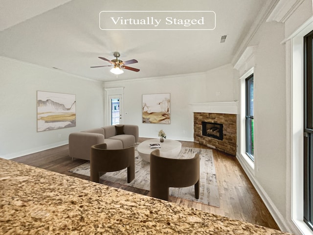 living room featuring ceiling fan, plenty of natural light, a fireplace, and dark hardwood / wood-style flooring