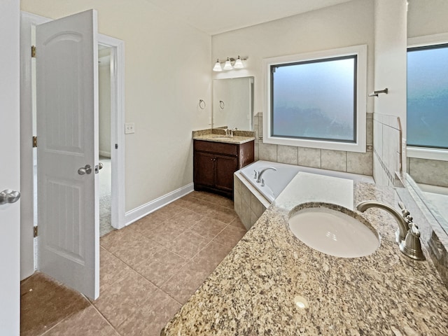 bathroom featuring tiled tub, vanity, and tile patterned floors