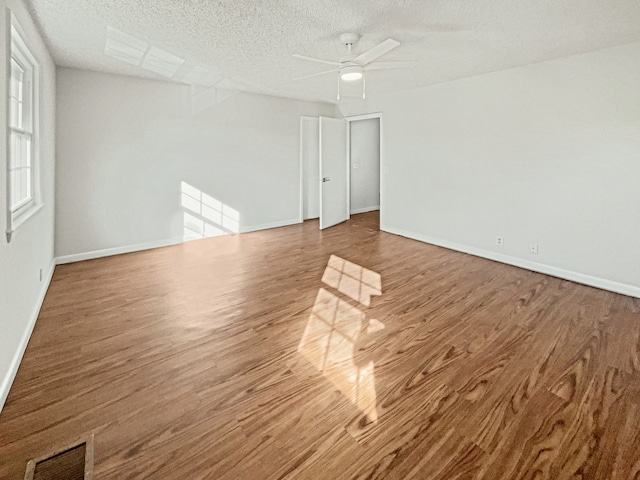 unfurnished room with ceiling fan, hardwood / wood-style floors, and a textured ceiling