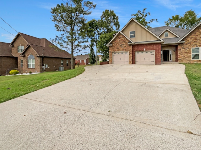 craftsman-style home featuring cooling unit, a garage, and a front yard