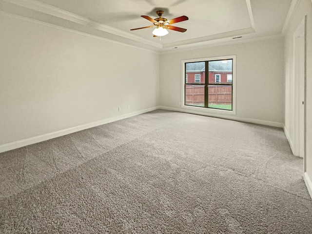 spare room featuring ceiling fan, a raised ceiling, carpet floors, and crown molding