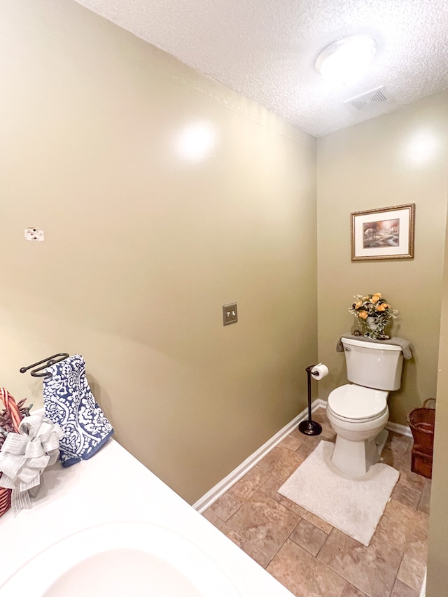 bathroom with a textured ceiling and toilet