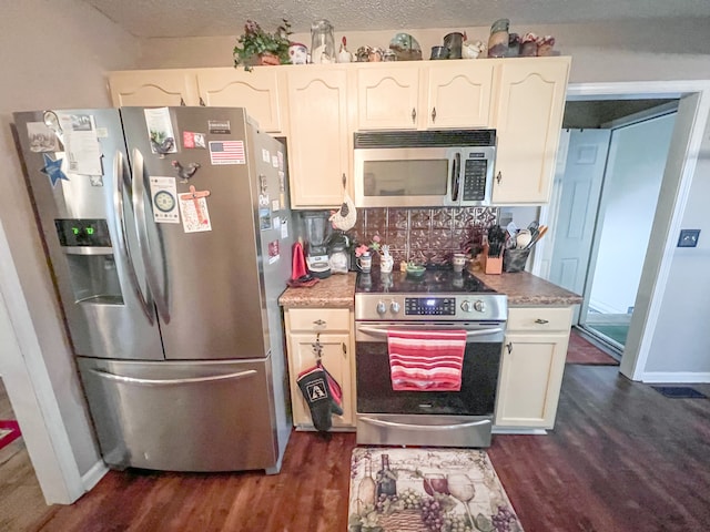 kitchen featuring a textured ceiling, stainless steel appliances, dark wood-type flooring, and white cabinetry