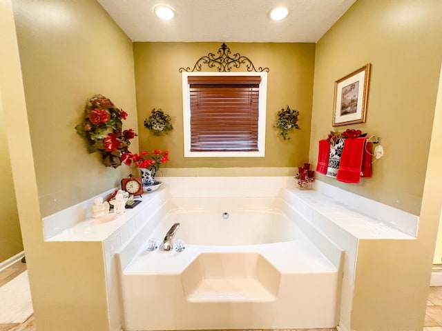 bathroom with tile patterned flooring and a tub