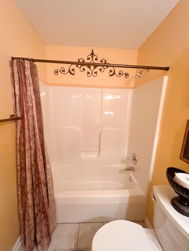 bathroom with tile patterned floors, a textured ceiling, shower / tub combo, and toilet