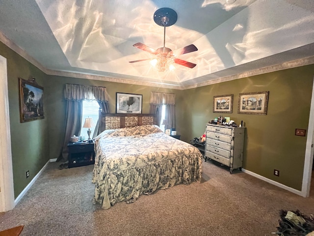 bedroom featuring ceiling fan, a raised ceiling, and carpet flooring